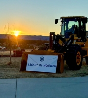Excavator with a banner hanging from it with the words: 